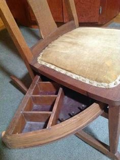 a wooden rocking chair with an open drawer underneath it