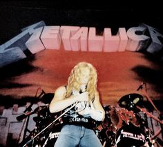 a woman with blonde hair playing guitar on stage