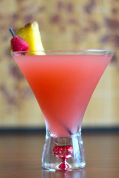 a pink drink with a lemon and raspberry garnish