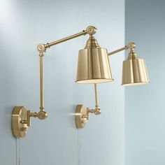 two lamps are on the wall next to each other, one is gold and the other is white