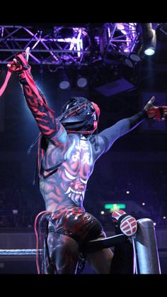 the wrestler is holding his arms in the air