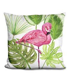 a pink flamingo sitting on top of a green leaf filled pillow