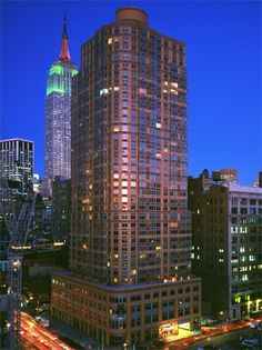 the city skyline is lit up at night, with tall buildings in the foreground