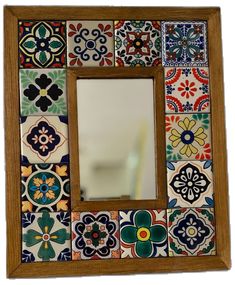 a mirror that is sitting on top of a tile wall with different colors and shapes