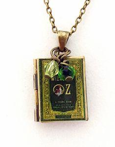 "Wizard of Oz Book Locket Necklace The locket opens to reveal two frames for the pictures of your choice.  Emerald green and a light green crystals accent the locket. The Wizard of Oz, movie, books, and play, is dear to so many of us!   Wear this Magical pendant necklace  to display your passion.  Necklace chain is alloy metal, antique gold in color. The chain closes with a lobster claw. Necklace is 18\" long.  Locket is 7/8\" long and 3/4\" wide in size. I also have many other Wizard of Oz jewe Light Green Crystals, Magical Pendant, Antique Gold Locket, Wizard Of Oz Book, Wizard Of Oz Movie, Book Locket Necklace, Graduation Gifts For Sister, Oz Movie, Vintage Book Cover