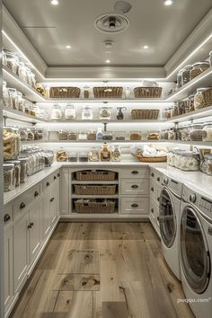 a large laundry room with lots of shelves and baskets on the wall next to washer and dryer