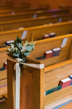 flowers are placed on the back of pews