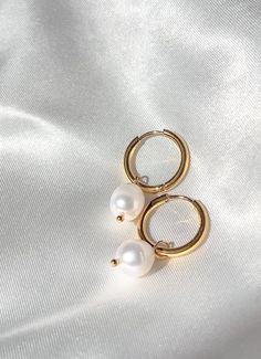 The Elora earrings are small hoop earrings adorned with a fresh water pearl. Simple and elegant, making them the perfect pair for a casual day out or a dressed up look. - Composed of - Stainless steel 18k gold plating Fresh water pearls tarnish free & hypoallergenic Everyday Pearl Charm Huggie Earrings, Elegant Everyday Pearl Huggie Earrings, Gold Small Hoop Earrings With Pearl Chain, Everyday 14k Gold Filled Pearl Pendant Earrings, Elegant Gold Huggie Earrings With Pearl Charm, Elegant Gold Pearl Huggie Earrings, 14k Gold Filled Hoop Earrings With Pearl Charm, Gift 14k Gold Hoop Earrings With Pearl Chain, Dainty Pearl Chain Hoop Earrings As Gift