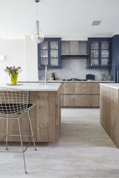 a modern kitchen with blue cabinets and marble counter tops