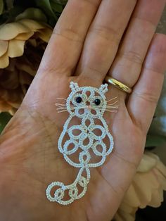 a cat brooch in the palm of someone's hand