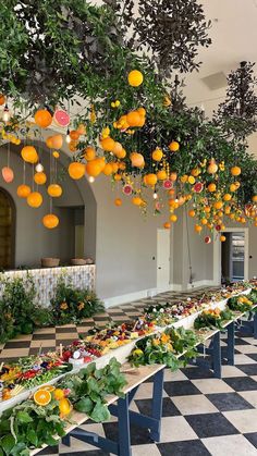 a long table with many oranges hanging from it