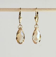 "- Gorgeous Swarovski Faceted Crystal Teardrop Briolette Earrings in our palest Gold shade in 14K Gold Filled Shell Detail Lever Backs with Self-Latch. See Photos #1-4. - Crystal Golden Shadow is Champagne or Honey and is the most elegant and lightest shade in this Crystal Collection. - 14K Gold Filled Jump Ring Connectors in Petite 4.5mm size. - 14K Gold Filled Lever Back Hooks with Shell Detailing. - See the same Earring in Bali Hooks or Studs with Ball Ends Listed separately. Photos #5-6. - D Briolette Earrings, Golden Shadow, Golden Earrings, Leverback Earrings, Swarovski Earrings, Pretty Earrings, Crystal Collection, Faceted Crystal, Earrings Collection