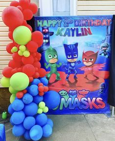 a birthday party with balloons and decorations on the front lawn, including an image of pj masks