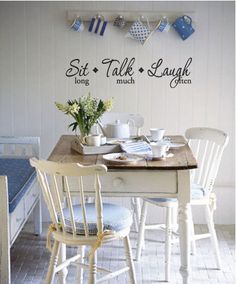 a kitchen table with chairs and plates on it