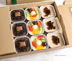 an open box filled with lots of different types of fruit and chocolates on top of each other