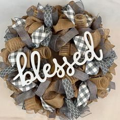 a welcome wreath with the word welcome hanging from it's center and plaid ribbon