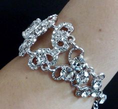 "A Victorian wedding style bridal bracelet made of clear swarovski crystals with a big oval cubic zirconia set onto detailed curl swirl frames in silver rhodium tarnish resistant finish. Bracelet crystal is 1 1/8\" (3cm) wide. Main focal crystal centerpiece is fixed at 1 1/2\" long while the rest are flexible joints. View matching pieces or similar designs at https://etsy.me/2sh8gPa View other Victorian inspired accessories https://etsy.me/2uAseFc View all bracelets at https://etsy.me/S9RHlf" Glamorous Silver Bracelets For Wedding, Silver Crystal Embellished Wedding Bracelet, Silver Crystal Embellished Bracelet For Wedding, Dazzling Silver Crystal Bracelet For Wedding, Silver Rhinestone Bracelets For Wedding, Wedding Crystal Bracelet With Handset Stones, Handset Stone Crystal Bracelet For Weddings, Silver Jeweled Crystal Bracelet For Wedding, Silver Jeweled Bracelets For Weddings