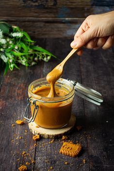 a hand holding a spoon full of peanut butter