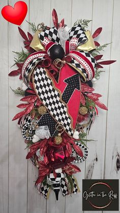 a christmas wreath hanging on the side of a wooden wall next to a red heart