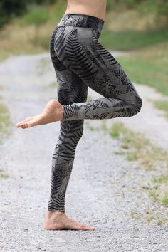 a person standing on one leg in the middle of a road with their legs spread out