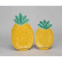 two yellow glass pineapples sitting side by side