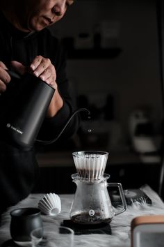 a man pouring coffee into a glass cup