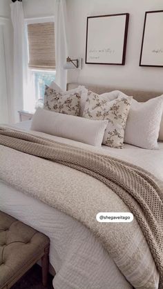 a bed with white sheets and pillows in a bedroom next to two pictures on the wall