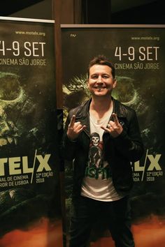 a man standing in front of two movie posters