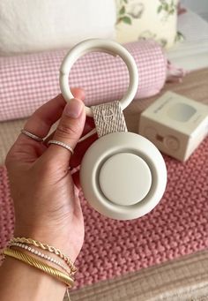 a person holding up a pair of headphones in their hand on a pink rug