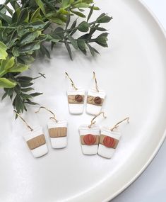 four small white and brown pieces of wood sitting on top of a plate next to a plant