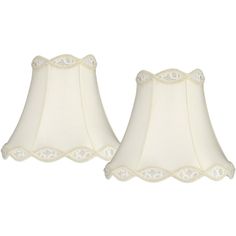 two white lamps with scalloped shades on them