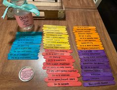 a wooden table topped with lots of different colored paper tags next to a bottle of water