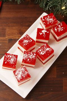 several pieces of red velvet cake on a white plate with christmas decorations in the background