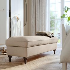 a grey ottoman sitting on top of a hard wood floor