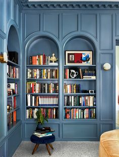 a living room with blue walls and bookshelves