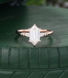 an emerald colored diamond ring sitting on top of a green tire