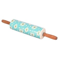 a rolling pin with daisies on it and wooden handles, sitting on a white background