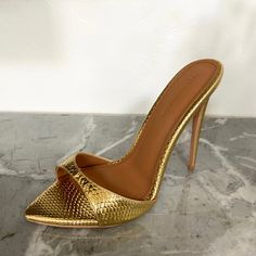 DUE TO HIGH DEMAND: THIS STYLE IS PRE ORDER WITH AN IN STOCK DATE OF SEPTEMBER 30TH ENJOY 20% OFF DURING PRE SALE PERIOD! (ENDS SOON) The sexiest stilettos you'll ever own! Gia is a minimal mule that will garner all the attention. Metallic Gold Vegan Leather with a faux reptile texture. Size and Fit Information: U.S. Sizing Available in whole and half sizes Runs true to size, but some customers size up a half size since it is an open back (Note: Not using leather and other materials from animals Gold Mules, Rich Women Lifestyle, Shiny Shoes, Stunning Shoes, Fancy Shoes, Only Shoes, Aesthetic Shoes, Stylish Shoes, High Heel Boots