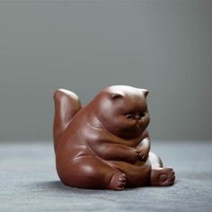 a brown bear figurine sitting on the ground