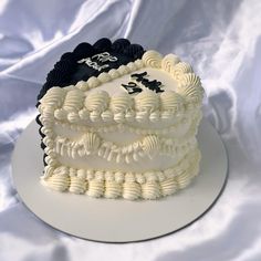 a white and black cake sitting on top of a plate