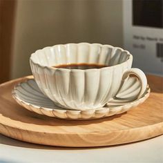 a coffee cup and saucer sitting on top of a wooden tray