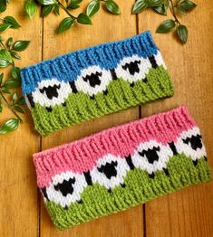 two knitted headbands sitting on top of a wooden table