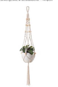 a white planter hanging from a rope with plants in it and the caption reads,