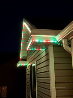 a house with christmas lights on the roof and gutter cover over it's windows