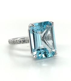 This gorgeous platinum ring features a large, 10.51 carat, emerald-cut blue topaz with beautiful bright, sky blue color! 24 sparkling diamonds weighing .50 carat total have been masterfully set by hand in the rounded band for a look that is stunning from all angles! A contemporary look that will never go out of style, this ring is perfect for every day and special occasions! Handcrafted in platinum by our Master Jewelers in Los Angeles. Blue topaz, 15.66 x 11.78 x 6.13mm, 10.51 caratsSize 6.25Co Jupiter Jewelry, Sky Blue Color, Aquamarine Ring, Diamond Cocktail Rings, Sky Blue Topaz, Aquamarine Rings, Platinum Ring, Sparkle Diamonds, Round Brilliant Cut Diamond