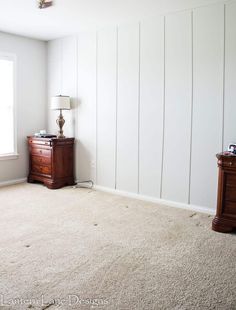 an empty room with two nightstands and a lamp