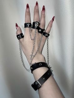 This uniquely designed bracelet features an integrated ring, connected by a stylish chain that adds a touch of avant-garde elegance. The bracelet is adorned with stud embellishments, while the ring showcases intricate decorations including skeleton motifs, crosses, and additional studs.  Please note that the price includes one bracelet with rings.  Ring Diameters: - Thumb, Index, and Middle Fingers: 6.5 cm - Ring and Pinky Fingers: 6 cm Party Jewelry With Metal Decoration, Punk Chain Jewelry For Alternative Fashion, Emo Jewelry With Adjustable Chain For Parties, Punk Style Chain Jewelry For Alternative Fashion, Emo Metal Jewelry With Adjustable Chain, Edgy Jewelry Bracelet Strap As Gift, Edgy Jewelry Bracelet Strap Gift, Edgy Bracelet Strap Jewelry Gift, Punk Style Metal Body Jewelry With Chain