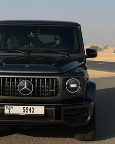 the front view of a black mercedes g - class