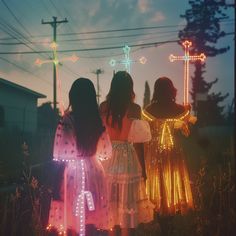 two girls are standing in front of the cross with lights on their shoulders and arms