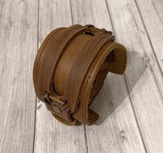 Wide cuff bracelet for men in casual and rustic zen brown leather. A thick matte leather strap. Its width and its raw leather give it its masculine character. It is made of a wide strip of leather enhanced with a narrower strip of leather.  For wrists 7-1/5 inch to 8-1/4 inch with 2 pressure adjustment sizes.  Measure your wrist well. To please him, a very masculine rustic bracelet, a gift for the rustic man, backpacker, biker  This rustic bracelet will seduce you with its vintage aged effect le Rustic Leather Cuff Bracelet With Leather Strap, Rustic Leather Cuff Bracelet, Distressed Brown Leather Cuff Bracelet, Rustic Brown Leather Strap Cuff Bracelet, Rugged Brown Leather Bracelet, Brown Waxed Finish Cuff Bracelet, Rugged Brown Leather Bracelet With Waxed Finish, Distressed Brown Leather Bracelet With Waxed Finish, Rustic Leather Bracelet With Strap